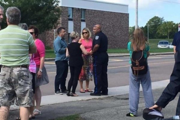 Charlottetown police Const. Tim Keizer speaks with parents, staff and students outside Colonel Gray High School in on Wednesday following the school evacuation order in P.E.I. (Shane Ross/CBC)